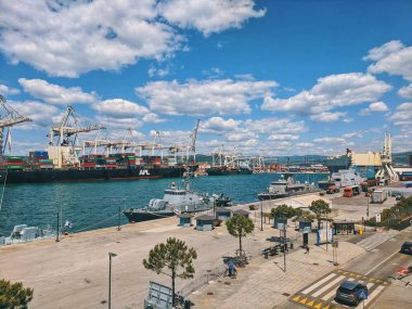 Scenic city view of Luka Koper at Adriatic seaside, Slovenia. Commercial cargo sea port with container cranes and ships. Pilot boats are anchored in the foreground.