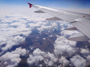 Güzel mavi gökyüzü manzarası ve yolcu koltuğundan kabarık bulutlar. Seyahat ve hava taşımacılığı kavramı.