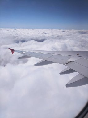 Güzel mavi gökyüzü manzarası ve yolcu koltuğundan kabarık bulutlar. Seyahat ve hava taşımacılığı kavramı.