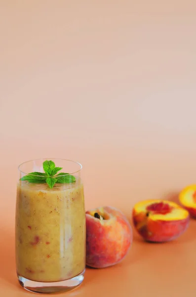 Top view of fresh healthy smoothie in a glass made of peach, banana and berries. Creative concept of healthy detox drink, diet or vegetarian food concept. Copy space.