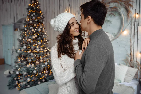 Mutlu romantik çift, Noel ağacının yanında durmuş birlikte vakit geçiriyorlar.