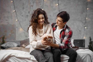 Erkek, kız arkadaşına bir hediyeyle sürpriz yapar. Kış tatilini sıcak Noel atmosferinde evde geçirir.