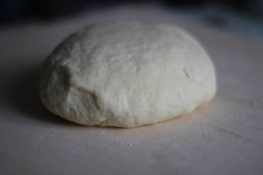 Tahta üzerinde yakın plan buğday unundan yapılmış hamur topu. Fırın, pasta, ev yapımı erişte, ekmek.