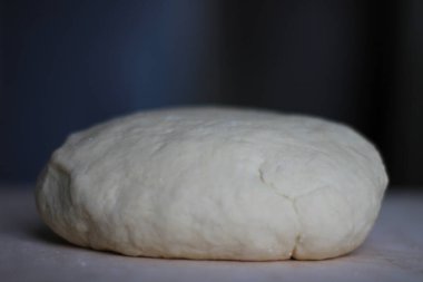 Tahta üzerinde yakın plan buğday unundan yapılmış hamur topu. Fırın, pasta, ev yapımı erişte, ekmek.