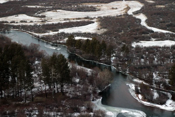 Dağın tepesinden donmuş nehir manzarası, sonbahar kış mevsimi. Ormanlar, çalılar, kaynak sularıyla nefes kesici vahşi yaşam manzarası
