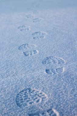 Kışın beyaz kar nehri yüzeyinde insan ayakkabısı tabanı ayak izleri. 