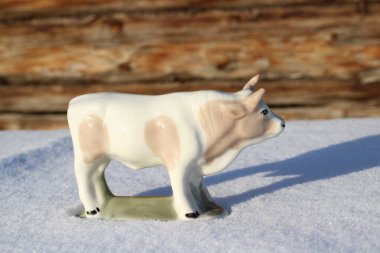 Ay takviminde 2021 Yılının Küçük Boğa Heykeli Sembolü. Boynuzlu Beyaz Benekli İnek Kışın Beyaz Kar Üzerinde 