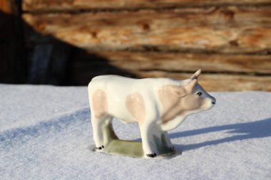 Ay takviminde 2021 Yılının Küçük Boğa Heykeli Sembolü. Boynuzlu Beyaz Benekli İnek Kışın Beyaz Kar Üzerinde 