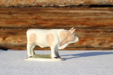 Ay takviminde 2021 Yılının Küçük Boğa Heykeli Sembolü. Boynuzlu Beyaz Benekli İnek Kışın Beyaz Kar Üzerinde 