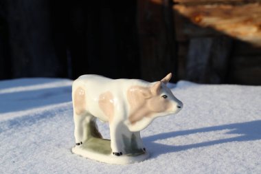 Ay takviminde 2021 Yılının Küçük Boğa Heykeli Sembolü. Boynuzlu Beyaz Benekli İnek Kışın Beyaz Kar Üzerinde 