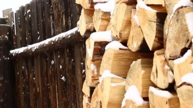 Beyaz Kar ile kaplı odun yığını. Kar yağışında çatlamış ahşap doku