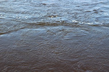 İlkbaharda akan dalgalı nehir yüzeyi