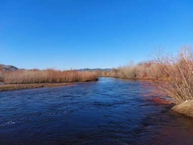 Bulutlu gökyüzünün altında akan nehir manzarası