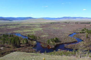 Nehir vadiyi ve ormanı geçerken Mavi Gök 'ün altındaki hava manzarası su yüzeyini ve ufuktaki dağları yansıtıyor. 