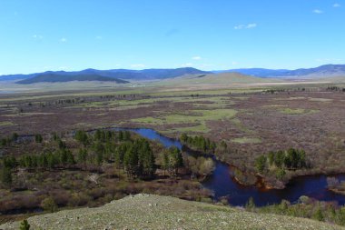 Nehir vadiyi ve ormanı geçerken Mavi Gök 'ün altındaki hava manzarası su yüzeyini ve ufuktaki dağları yansıtıyor. 