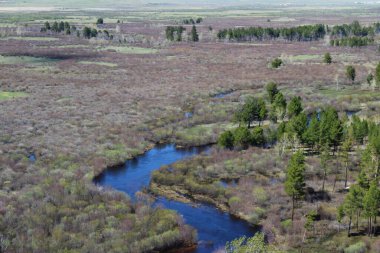 Nehir vadiyi ve ormanı geçerken Mavi Gök 'ün altındaki hava manzarası su yüzeyini ve ufuktaki dağları yansıtıyor. 