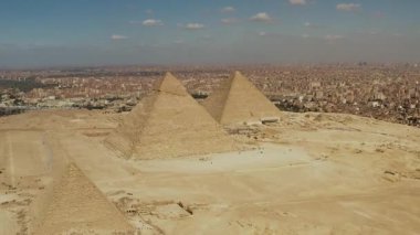 Giza piramitlerinin bir dron tarafından yakalanan hava görüntüsü Giza 'nın ikonik piramitlerini yukarıdan gösteriyor. İnsansız hava aracı perspektifi ile bu antik harikanın çarpıcı görüntülerini tecrübe edin..
