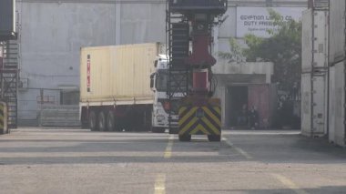 Port Said, Mısır - 7 Aralık 2020: Bu hareketli liman faaliyetlerini ve lojistik operasyonlarını gözler önüne seren Port Said Limanı 'nda bir gantry vinç ile birlikte istiflenmiş nakliye konteynerleri sergilenmektedir..