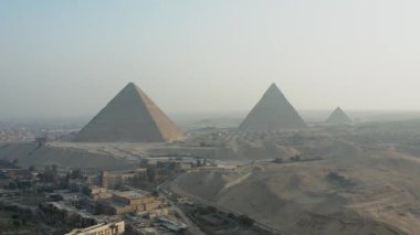 İnsansız hava aracı Giza 'nın muhteşem piramitlerinin hava görüntüsünü yakalıyor. Giza piramitlerinin göz kamaştırıcı güzelliğini ve ihtişamını yukarıdan görün. Bu ikonik tarihi mekanı sergiliyor..
