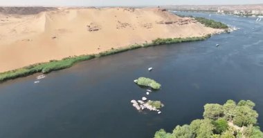 Aswan Mısır - 17 Eylül 2023: Aswans Nil yukarıdan nefes kesici görüntüler sunuyor. Kayalık adalar ve gün ışığında aydınlatılmış geleneksel yelkenliler, doğa severler ve macera arayanlar için bir hedef olmalı..