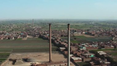 Şehirdeki büyük bir bacanın havadan görünüşü. Bu eski tuğla fabrikası, tarihi mimarisini ve endüstriyel önemini sergiliyor. Geçmiş üretim alanları hakkında bilgi sağlıyor..