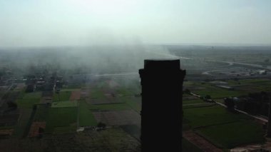 Şehirdeki eski bir borunun ya da bacanın havadan görünüşü. Antika tuğla fabrikasının yapısını gösteriyor. Bu görüntü, kentsel endüstriyel mimarinin tarihsel özünü yakalar..