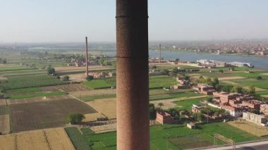 Şehirdeki eski bir borunun ya da bacanın havadan görüntüsü. Bu eski tuğla fabrikası endüstriyel mimariyi sergiliyor ve şehrin tarihi imalat manzarası hakkında bilgi sağlıyor..