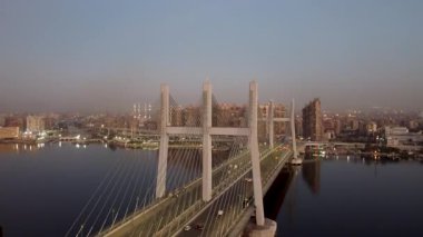 Günbatımında Tahya Misr köprüsünün ve Rod alFarag ekseninin nefes kesici görüntülerini ve manzaranın canlı renklerini gösteren çarpıcı insansız hava aracı görüntülerini tecrübe edin..