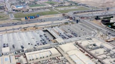 Giza, Mısır - 10 Nisan 2021: Mısır AVM otoparkının hava görüntüsü geniş alana park etmiş çok sayıda arabayı gösteriyor, bu alışveriş merkezinin yoğun aktivitesini ve rahatlığını vurguluyor.