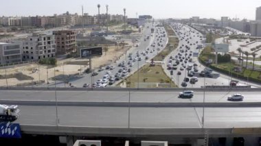 Giza, Mısır - 10 Nisan 2021: Hava perspektifi aktif trafik ve aşağıda hareket eden arabalarla El Mehwar 'ı gösteriyor. El Mehwar 'ın bu büyüleyici hava sahnesinde dinamik yol manzarasını deneyin..