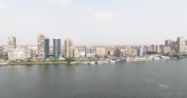 Kahire Mısır - 29 Mart 2024: Kahire 'de Kornish AlMaadis' in korniş görüntülerini gösteren gündüz insansız hava aracı görüntüleri. Yüksek binalara, manzaralı Nil Nehri 'ne ve çarpıcı detaylarıyla hareketli turistik teknelere hayranım..