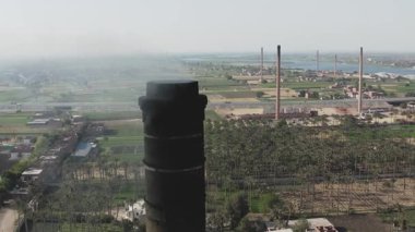 Şehirdeki büyük tarihi bir bacanın havadan görünüşü, eski tuğla fabrikasının yapısını gösteriyor. Bu resim, kentsel ortamlardaki sanayi mirasının mimari kalıntılarını vurgular.