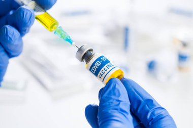 Coronavirus COVID-19 aşı geliştirme, hasta tedavi ve tedavi araştırmaları, SARS-CoV-2 patojeni ile mücadelede çığır açan bulgular, ellerinde ampul ve şırınga tutan eldivenler