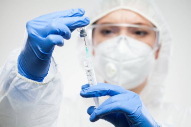 Şırınga ve ampul tutan kadın bilim adamı, laboratuvar kıyafeti, koruyucu eldivenler, yüz maskesi ve gözlük, COVID-19 aşı illüstrasyonu, küresel Coronavirus salgınının tedavisi