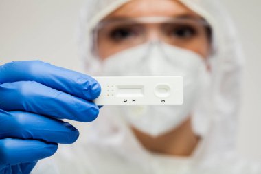 Coronavirus COVID-19 hızlı teşhis kiti taşıyan Birleşik Krallık Sağlık Hizmetleri NHS ön cephesi. Acil tıbbi tarama için basit RDT testi. Aynı gün sonuç elde etmek için bakım laboratuarı testi noktası.