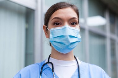Çok yorgun İngiliz NHS yoğun bakım doktorunun hastane önündeki portresi, Coronavirus COVID-19 salgın krizi, uzun vardiyalarda çalışan uykusuz EMS tıbbi personeli, acil servis hasta tedavisi