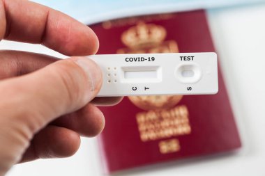 Person holding COVID-19 serological rapid diagnostic test,at home or point of care testing procedure,immunity passport or health passport concept,proof of immunization,risk free certificate document clipart