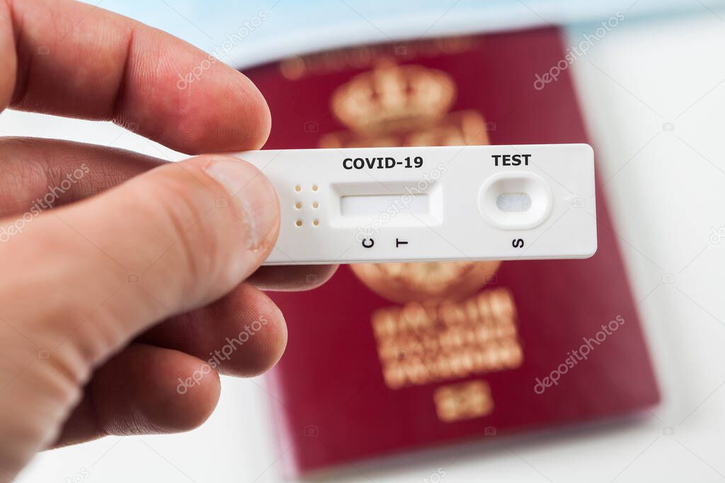 Person holding COVID-19 serological rapid diagnostic test,at home or point of care testing procedure,immunity passport or health passport concept,proof of immunization,risk free certificate document