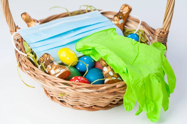 Easter basket with medical face mask and latex rubber gloves,traditional festive holiday in time of global Coronavirus COVID-19 corona virus disease pandemic,worldwide health crisis,social distancing