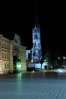 Devlet binası ve bir Katolik kilisesinin kulesi gece Vaduz, Lihtenştayn 31.3.2021