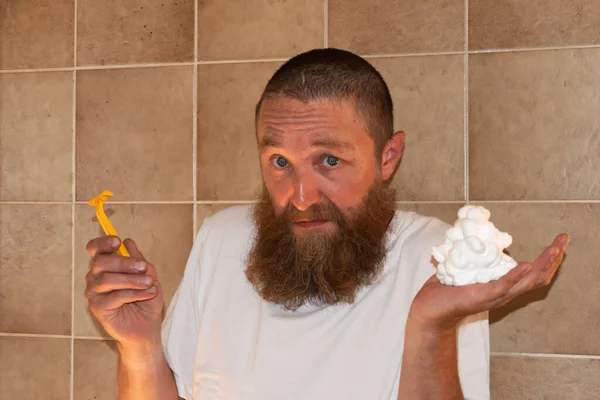 Vaduz, Liechtenstein July 1, 2021 A man with a big beard is standing in a bathroom with his shaver