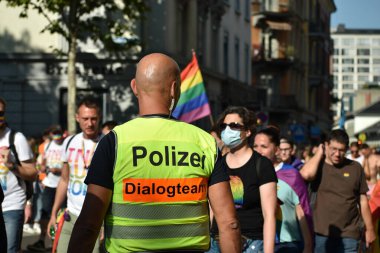 ZURICH, SWitzERLAND, 4 EYLÜL, 2021 Polis memuru, şehir merkezindeki eşcinsel onur gösterisi sırasında barışçıl protestocularla ilgilenir.
