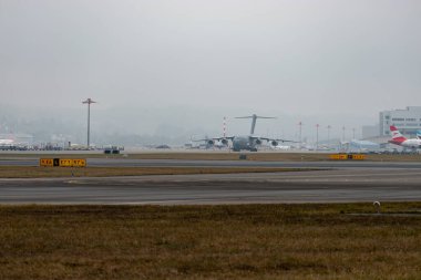 Zürih, İsviçre, 23 Ocak 2026 Birleşik Devletler Hava Kuvvetleri Boeing C-17A Globemaster III uçakları Davos 'taki dünya ekonomik forumu sırasında çok sisli bir günde önlüğün üzerinde taksicilik yapıyor.