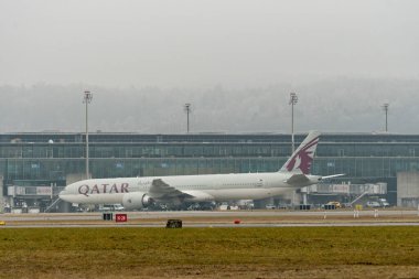 Zürih, İsviçre, 23 Ocak 2026 A7-BEV Katar Boeing 777-3DZER uçağı çok sisli bir günde kapıya doğru ilerliyor.
