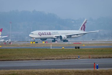 Zürih, İsviçre, 23 Ocak 2026 A7-BEV Katar Havayolları Boeing 777-3DZER uçağı çok sisli bir günde 28 numaralı pistten kalkıyor.