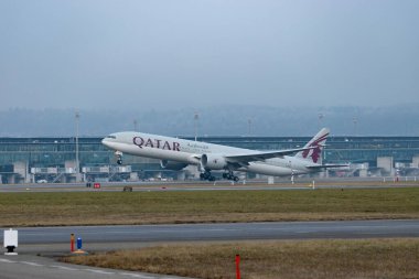 Zürih, İsviçre, 23 Ocak 2026 A7-BEV Katar Havayolları Boeing 777-3DZER uçağı çok sisli bir günde 28 numaralı pistten kalkıyor.