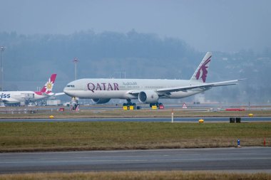 Zürih, İsviçre, 23 Ocak 2026 A7-BEV Katar Havayolları Boeing 777-3DZER uçağı çok sisli bir günde 28 numaralı pistten kalkıyor.