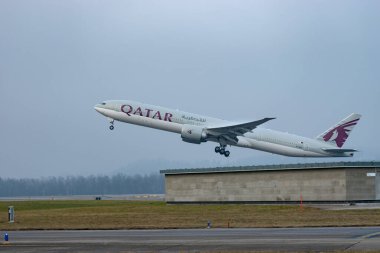 Zürih, İsviçre, 23 Ocak 2026 A7-BEV Katar Havayolları Boeing 777-3DZER uçağı çok sisli bir günde 28 numaralı pistten kalkıyor.