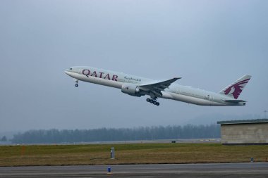 Zürih, İsviçre, 23 Ocak 2026 A7-BEV Katar Havayolları Boeing 777-3DZER uçağı çok sisli bir günde 28 numaralı pistten kalkıyor.