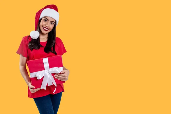 Frau Mit Weihnachtsmütze Hält Ein Geschenk Isoliert Auf Gelbem Hintergrund — Stockfoto